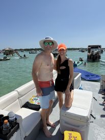 A cheerful couple poses on a boat in sunny weather, enjoying their time on the water — perfect for summer adventures and memorable outings.
