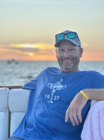 A man relaxes on a boat at sunset, enjoying the serene view and the perfect atmosphere for a memorable evening on the water.