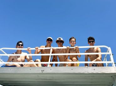 A group of friends enjoys a sunny day on a boat, showcasing the fun and camaraderie of summer adventures on the water.