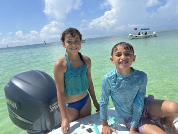 Two children enjoy a sunny day by the water, showcasing the joy of family fun and beach activities in a tropical paradise.