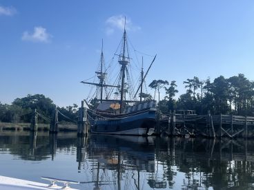 A majestic sailing ship docked at a serene location, reflecting beautifully in the calm waters — a perfect sight for maritime enthusiasts.