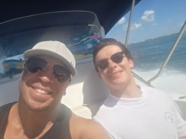 Two friends enjoy a sunny day on the water, capturing a joyful moment aboard their boat. Perfect for showcasing fun outings and adventures on the sea.