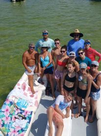 A lively group of friends and family gather on a boat, enjoying a sunny day on the water — perfect for summer adventures and memorable outings.