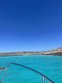 A vibrant scene of turquoise waters and a bustling beach, showcasing a perfect day for swimming and relaxation. Ideal for those looking to enjoy sun-soaked adventures.