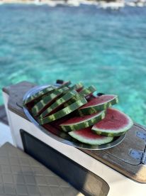 A refreshing platter of watermelon slices ready for enjoyment on a boat, perfect for summer outings and tropical adventures.