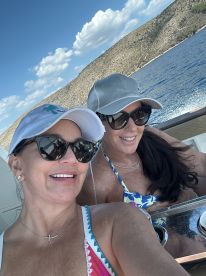 Two friends enjoy a sunny day on the boat, capturing a joyful moment with smiles and laughter — perfect for memorable outings on the water.