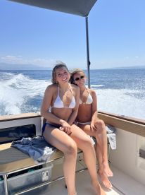 Two friends enjoy a sunny day on a boat, capturing the essence of summer fun and friendship on the water.