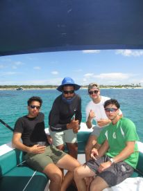 A group of friends enjoys a fun day on the water, showcasing camaraderie and relaxation aboard a boat with drinks in hand.