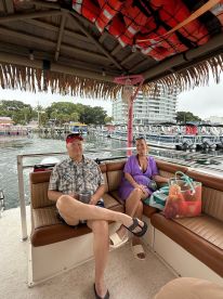 Two guests relax in the cozy lounge area of a boat, enjoying the scenic waterfront view — perfect for a leisurely day on the water.