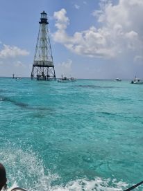 A stunning view of a lighthouse surrounded by vibrant turquoise waters, capturing the essence of a perfect boating adventure.