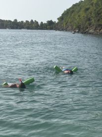 Two individuals enjoy snorkeling in calm waters, showcasing a fun and adventurous day on the water — perfect for family outings or group activities.