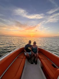 A couple enjoys a romantic sunset on a boat, creating the perfect backdrop for memorable moments on the water.