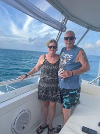 A couple enjoys their time aboard a boat, capturing a moment of joy against the backdrop of the ocean — perfect for romantic getaways or memorable adventures.