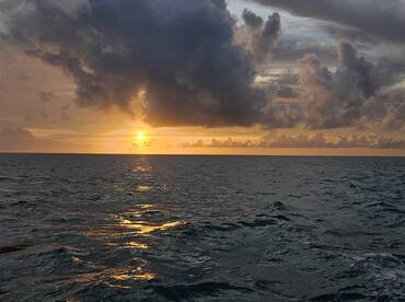 A stunning sunset over the ocean, with vibrant colors reflecting on the water's surface — a perfect backdrop for serene boating experiences.