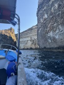 A scenic view from a boat navigating through stunning cliffs, showcasing the natural beauty of the coastline.