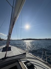 A stunning view from the deck of a sailboat, showcasing the shimmering water and bright sun — perfect for a day of sailing adventures.
