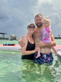 A joyful family enjoys a fun day in the water, creating lasting memories together. Perfect for showcasing family-friendly beach activities.