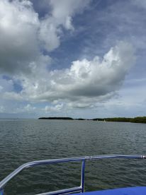 A serene view of the coastline and clouds over calm waters, perfect for showcasing the beauty of a boating adventure.