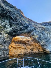 A stunning view of a natural rock arch from a boat, showcasing the beautiful coastal scenery — perfect for exploring unique landmarks on water adventures.