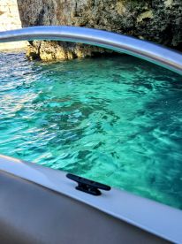 An unclear view from a boat showing turquoise waters and rocky surroundings, lacking a clear subject or focus.