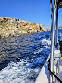 A scenic view from a boat cruising along a rugged coastline, showcasing the beauty of the natural landscape and the thrill of being on the water.