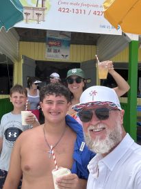 A joyful group of family members enjoys refreshing cocktails together, capturing a fun moment during their island adventure.