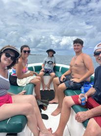 A cheerful group of family members enjoys a relaxing day on the boat, capturing the essence of summer fun and togetherness on the water.