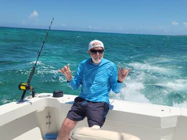 A man enjoys a day of fishing on the open ocean, showcasing a relaxed vibe while aboard a boat — perfect for adventure seekers and fishing enthusiasts.