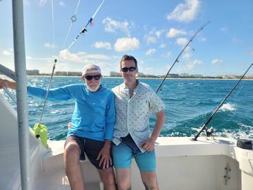 Two friends enjoy a day of fishing on a boat, surrounded by beautiful ocean views — a perfect adventure for fishing enthusiasts.