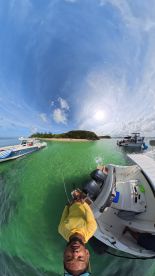 A vibrant scene captures a group enjoying a fishing trip near a picturesque island, with boats anchored in the clear waters — perfect for adventure seekers.