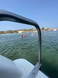 A lively scene captures a group enjoying a sunny day at the beach, swimming with inflatable toys in clear waters — perfect for family fun and summer adventures.