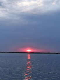 A stunning sunset reflects on calm waters, creating a serene atmosphere perfect for evening boat cruises.