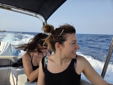 Two friends enjoy a thrilling ride on a boat, capturing the joy of on-water adventures with smiles and the wind in their hair.