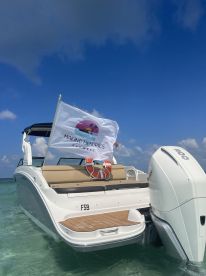 A sleek boat with a 'Making Memories' flag is anchored in clear waters, showcasing a perfect day for boating adventures in Key West.
