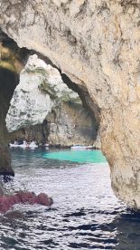 A stunning view of kayakers exploring a beautiful cave, surrounded by crystal-clear waters — a perfect adventure for nature lovers.