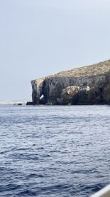 A stunning view of a rocky coastline from the water, showcasing the natural beauty of the landscape — perfect for scenic boat tours.