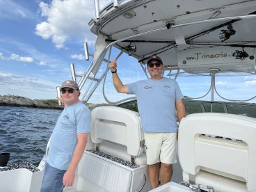 Two men enjoy the helm of a boat, showcasing the interior space and inviting atmosphere for a day on the water.