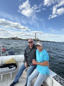 A couple enjoys a scenic boat ride with a lighthouse in the background, perfect for romantic outings and exploring coastal views.