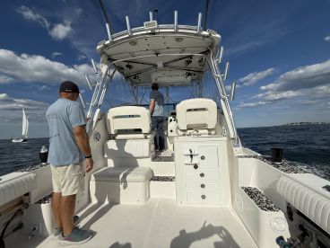 A view of the interior helm of a boat with two crew members preparing for navigation, showcasing the modern console and seating area.