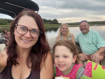 A joyful family enjoys a day on the water aboard a pontoon boat, capturing smiles and memories together in a scenic setting.