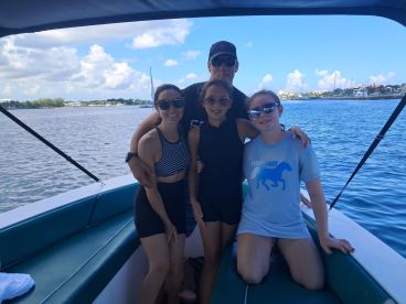 A joyful family poses together on a boat, capturing a memorable moment on the water — perfect for family outings and adventures.
