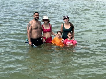 A joyful family enjoys snorkeling together in shallow waters, creating unforgettable memories during their aquatic adventure.