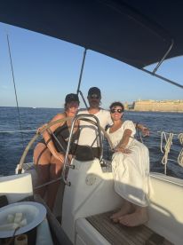 A joyful group enjoys a sailing experience on a yacht, capturing the essence of friendship and adventure on the water.