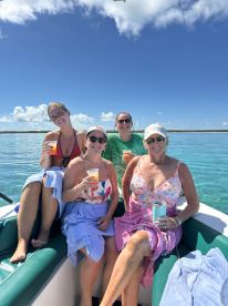 A cheerful group of friends enjoys cocktails on a sunny day aboard a boat, creating unforgettable memories in crystal-clear waters.