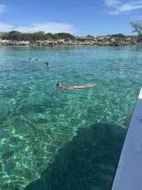A group enjoys snorkeling in crystal-clear waters, showcasing the vibrant marine life and stunning underwater scenery — a perfect adventure for water enthusiasts.
