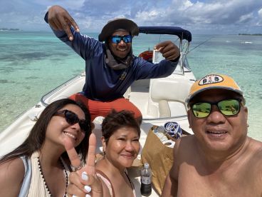 A joyful group poses for a selfie on a boat, enjoying their time in the beautiful turquoise waters — perfect for memorable outings and adventures.