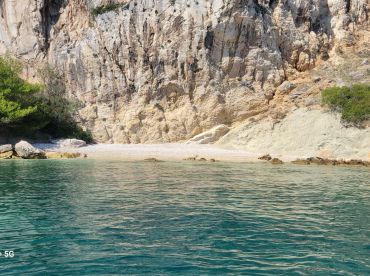 A stunning view of a secluded beach framed by rocky cliffs, perfect for exploring hidden gems along the coastline.