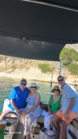 A cheerful group enjoys a day on the water, capturing memories aboard their boat against a scenic backdrop.