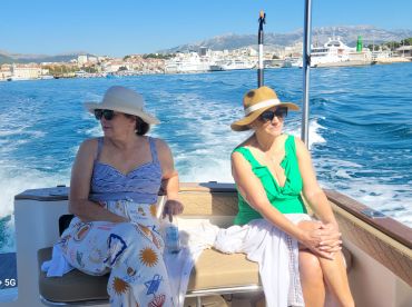 Two women enjoy a relaxing cruise on a sunny day, showcasing the perfect atmosphere for a leisurely boat trip.