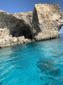 A stunning view of a rocky coastline with crystal-clear turquoise waters, perfect for exploring natural wonders while boating.